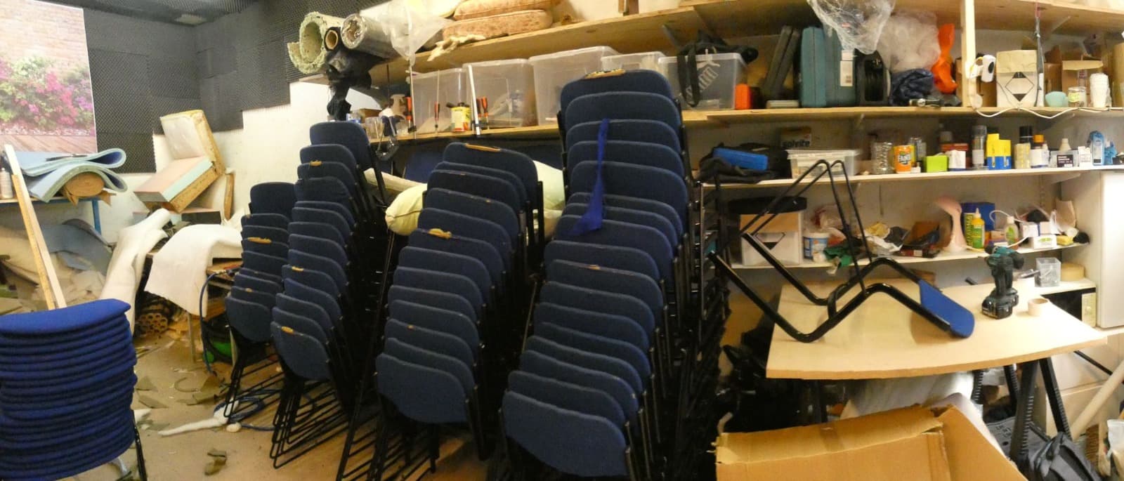 Kennington Upholstery workshop with stacked chairs being reupholstered