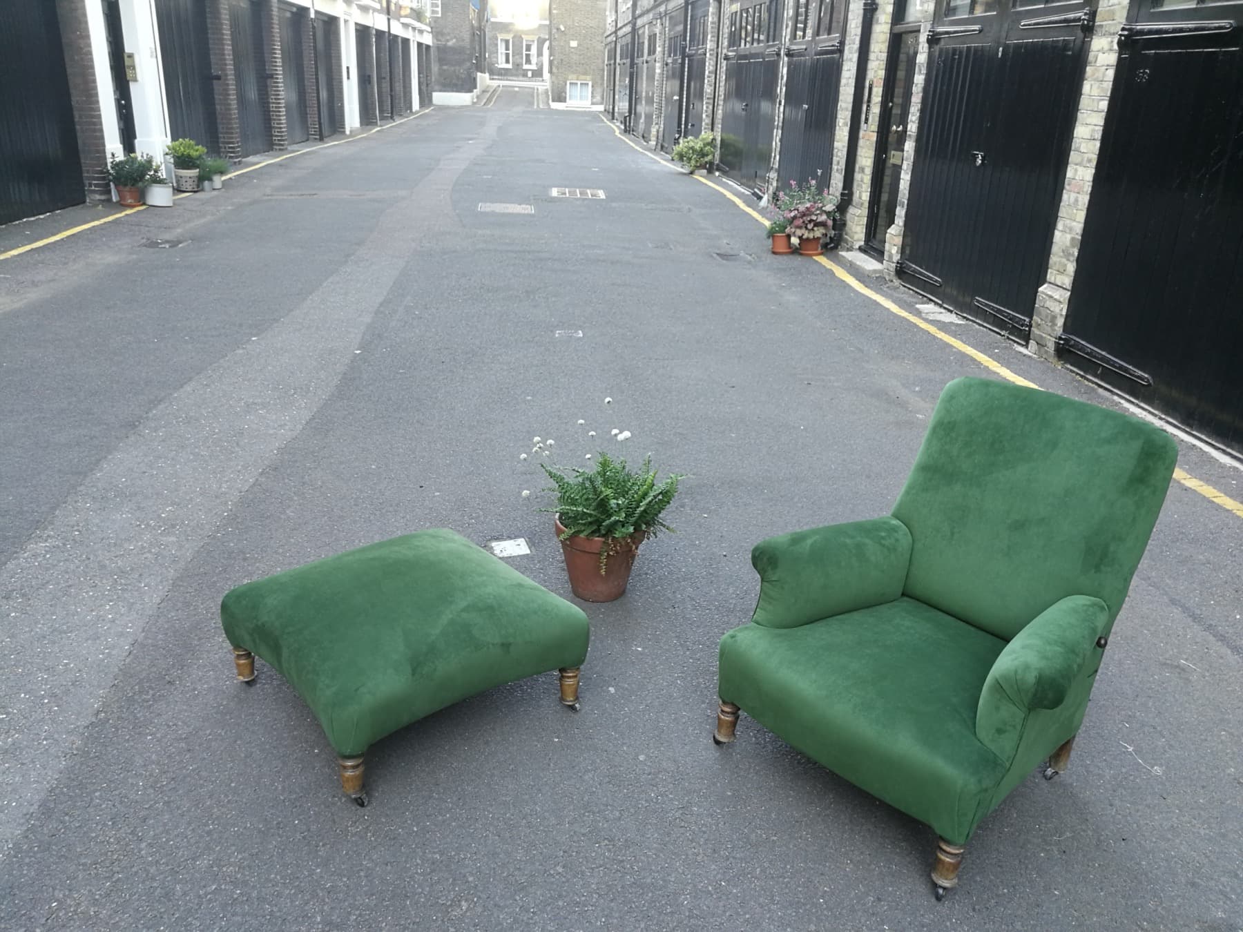 Green velvet armchair and matching footstool reupholstered in London