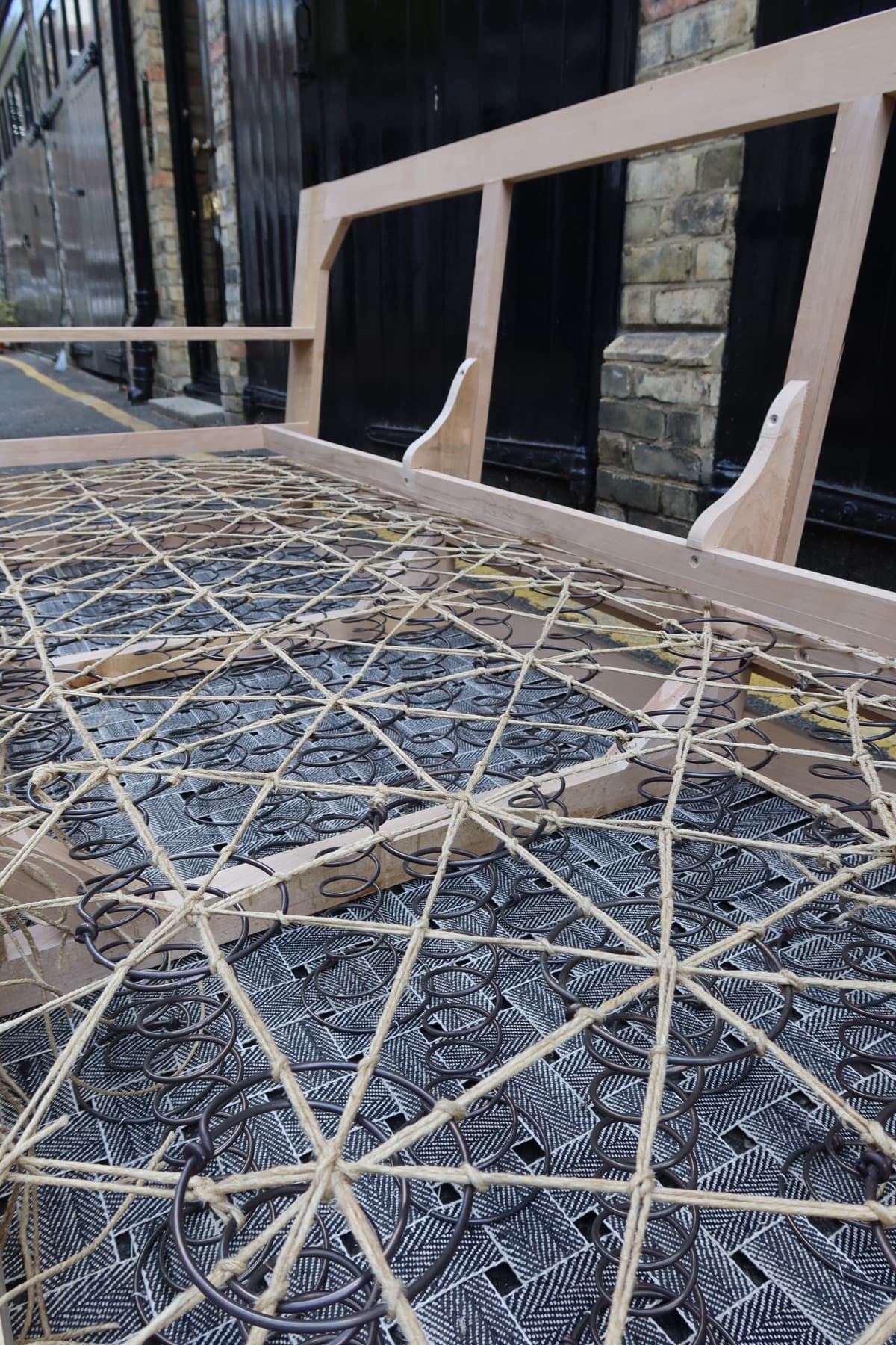 Separate workshop example of hand-tied springs and webbing on an upholstery frame