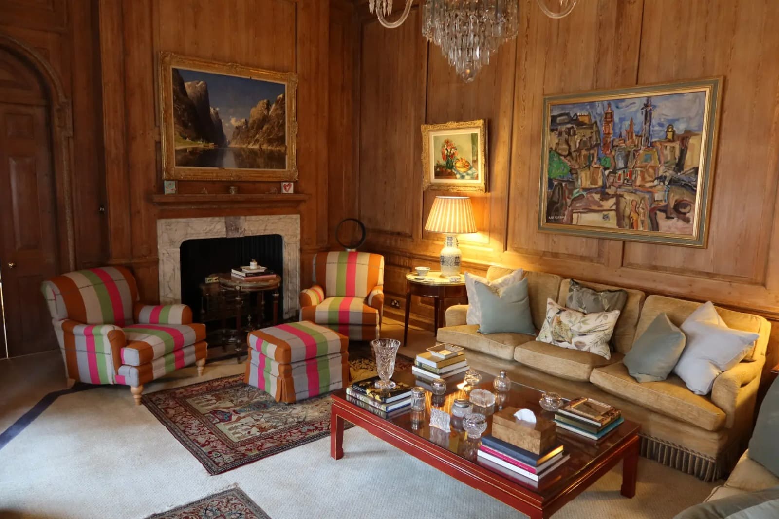 Reupholstered armchairs and sofa in a traditional wood-panelled living room